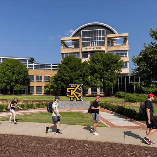 ksu students on kennesaw campus passing kennesaw hall.