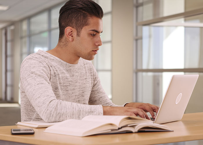 Young student typing on their laptop