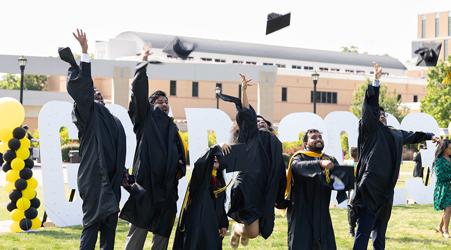 KSU students in front of grad letters