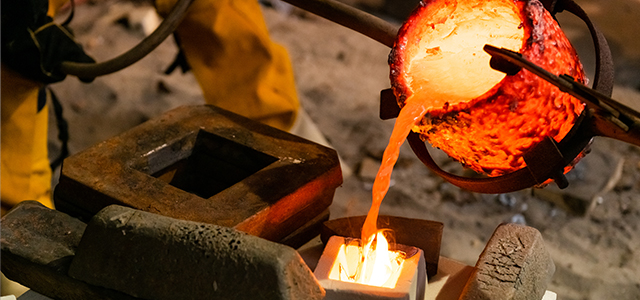 ksu student pouring hot metal into mold