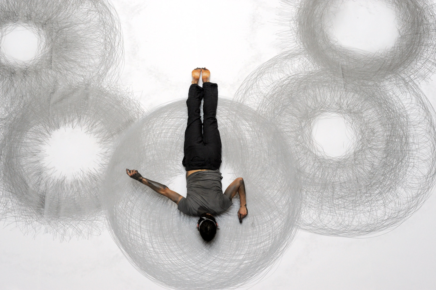 image of man laying down on white floor and drawing