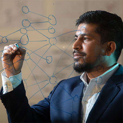 man writing on a glass window with a expo marker.