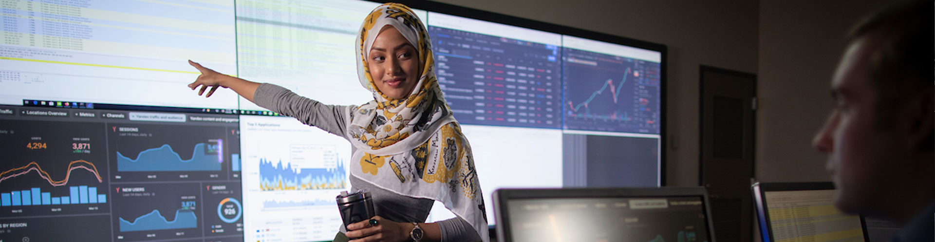 CCSE student pointing at charts and graphs information on the screen.