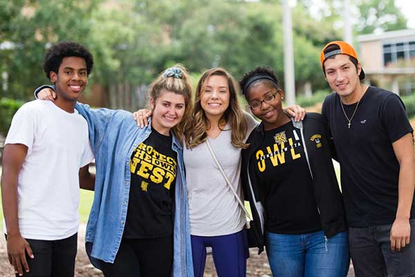 ksu students on campus huddled arm in arm looking at camera