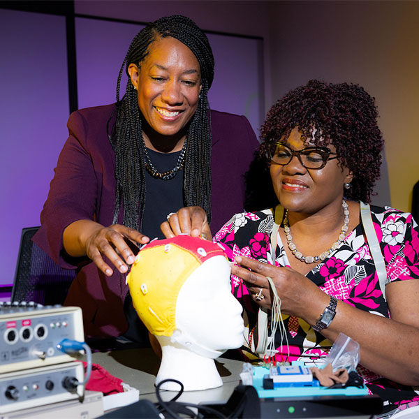 two ksu brainlab students working on a test dummy