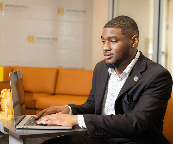 ksu business student using his laptop