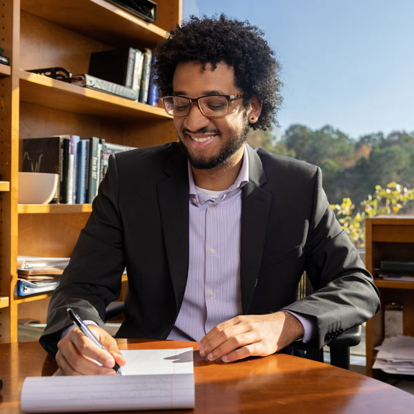 KSU student taking notes on business management.