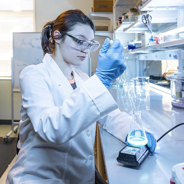 chemistry student holding lab equipment