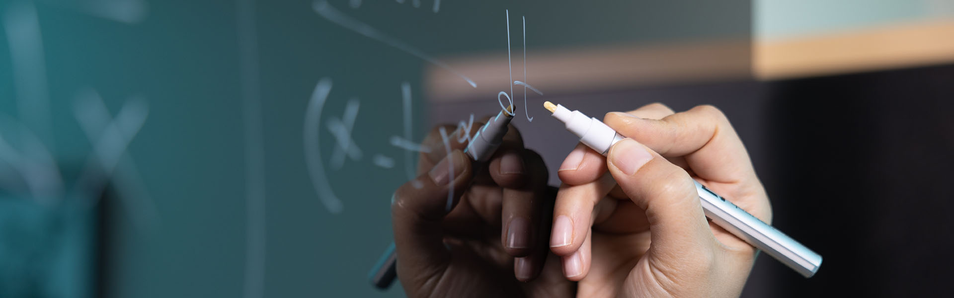 Photo of student hand holding a pen solving a math equation