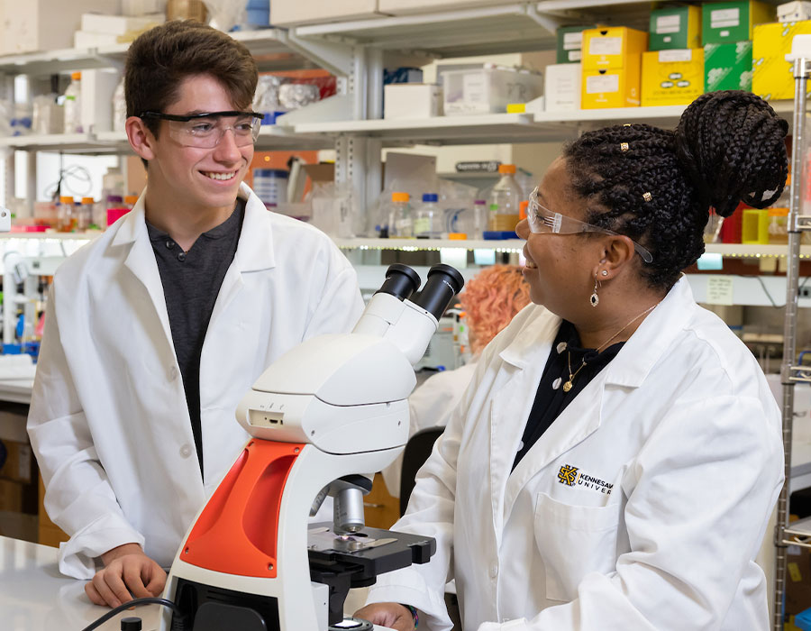 ksu student and faculty using a microscope for research