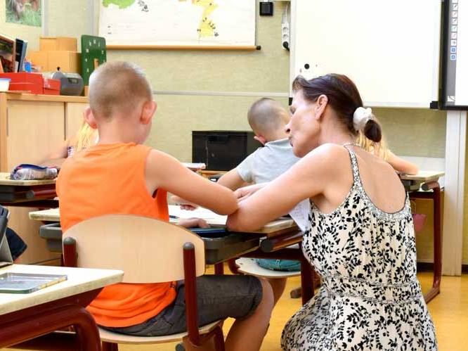 Woman is helping younger child with school work