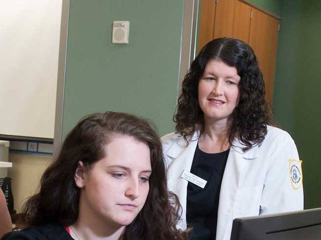 Woman is observing student while focusing on computer