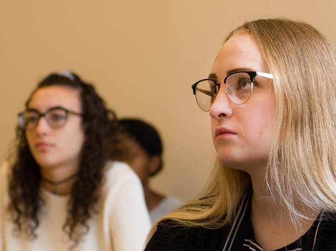 Two students seated focusing