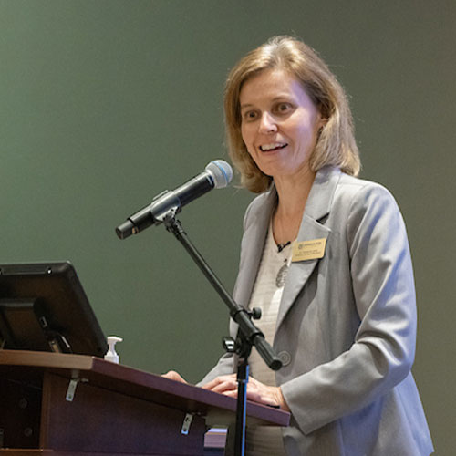 Woman with tablet infront of her speaking into a microphone