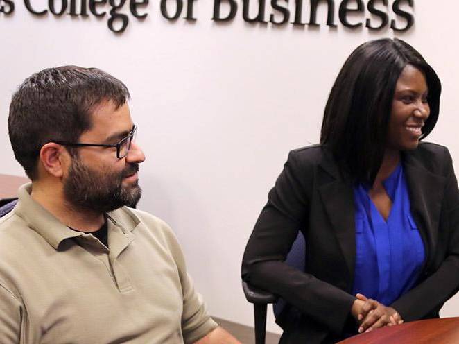 Business man and woman sitting at desk communicating