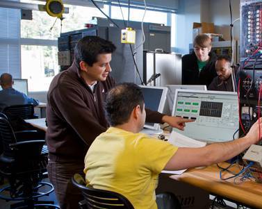 Two men focusing on laptop communicating