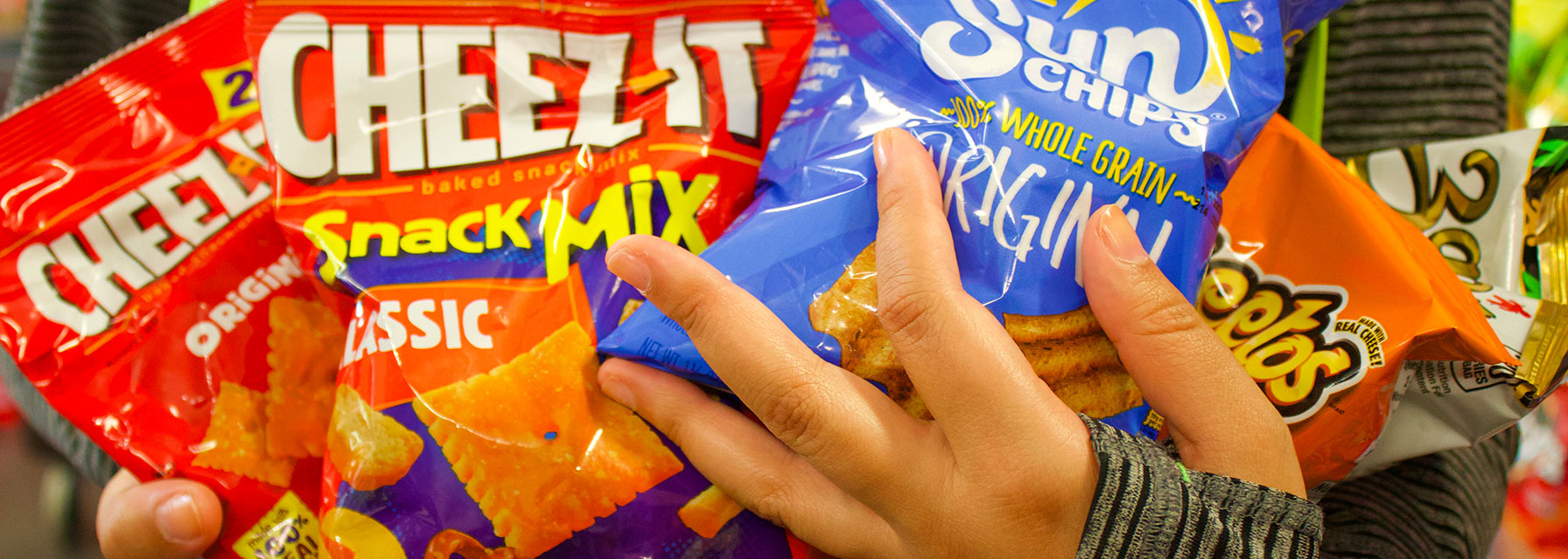 Student holding an assortment of chips at The Market