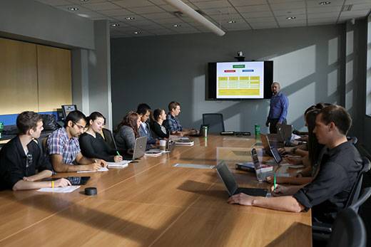 People sitting at a desk looking at a projector