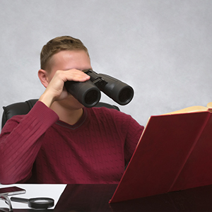 student reading book with binoculars