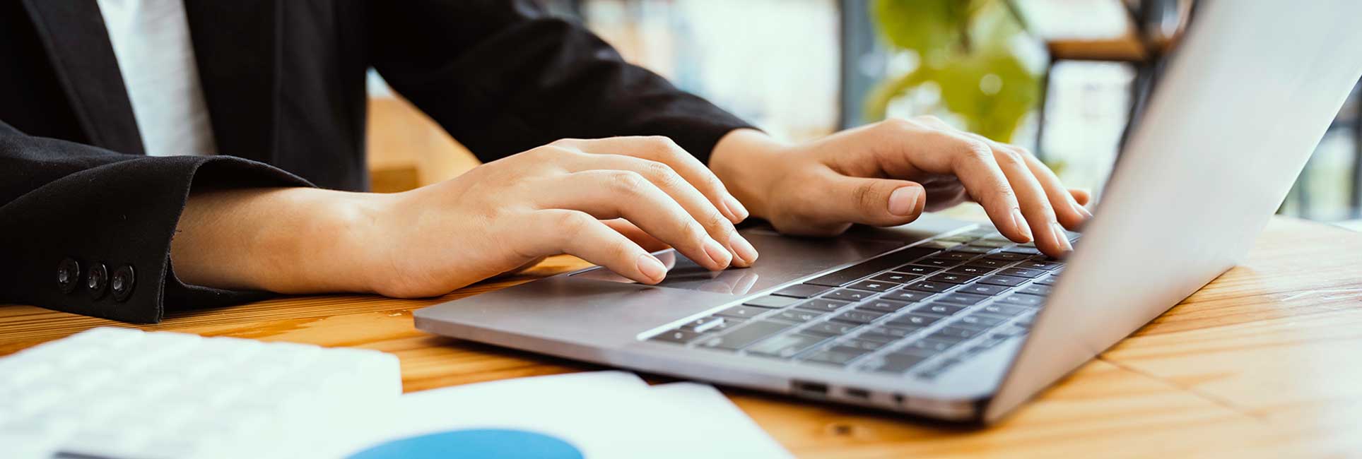 hands typing on a laptop computer.