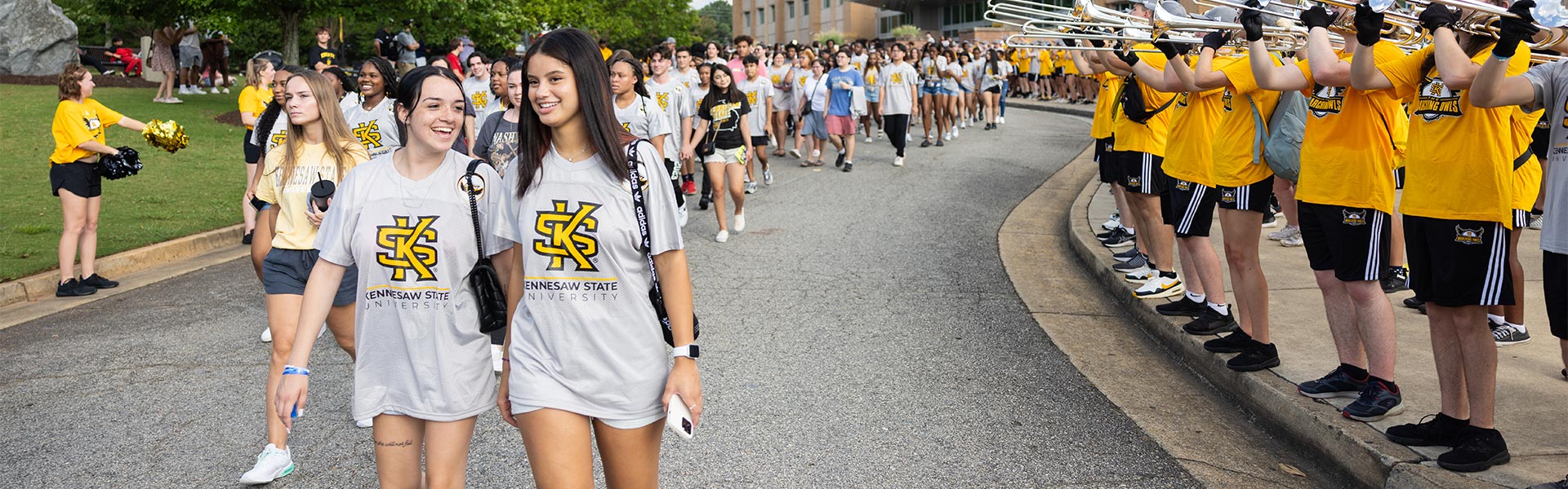 large group of first flight students walking on campus.