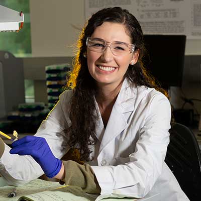 Smiling student in lab coat