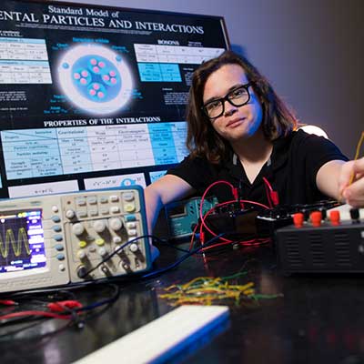 student at desk with electronic devices