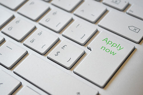 Photo of a keyboard with apply now written on the return key