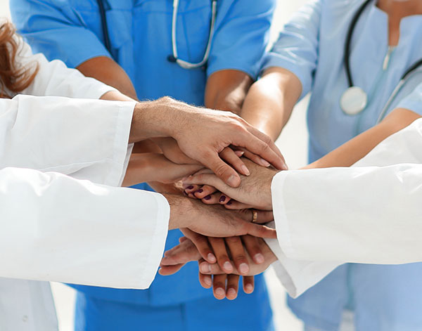 Doctors and nurses stacking hands a concept of mutual aid.