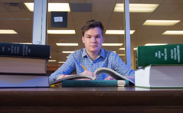 ksu student sitting at a table with books on it.