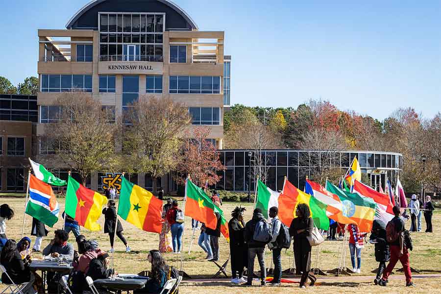 students holding global flags on the campuse green