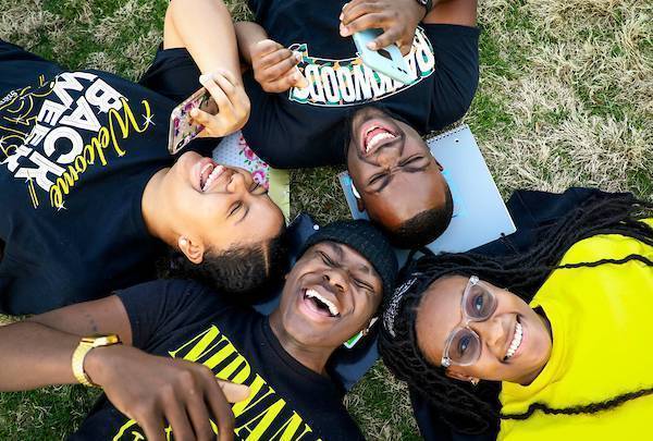 students laying in the grass laughing