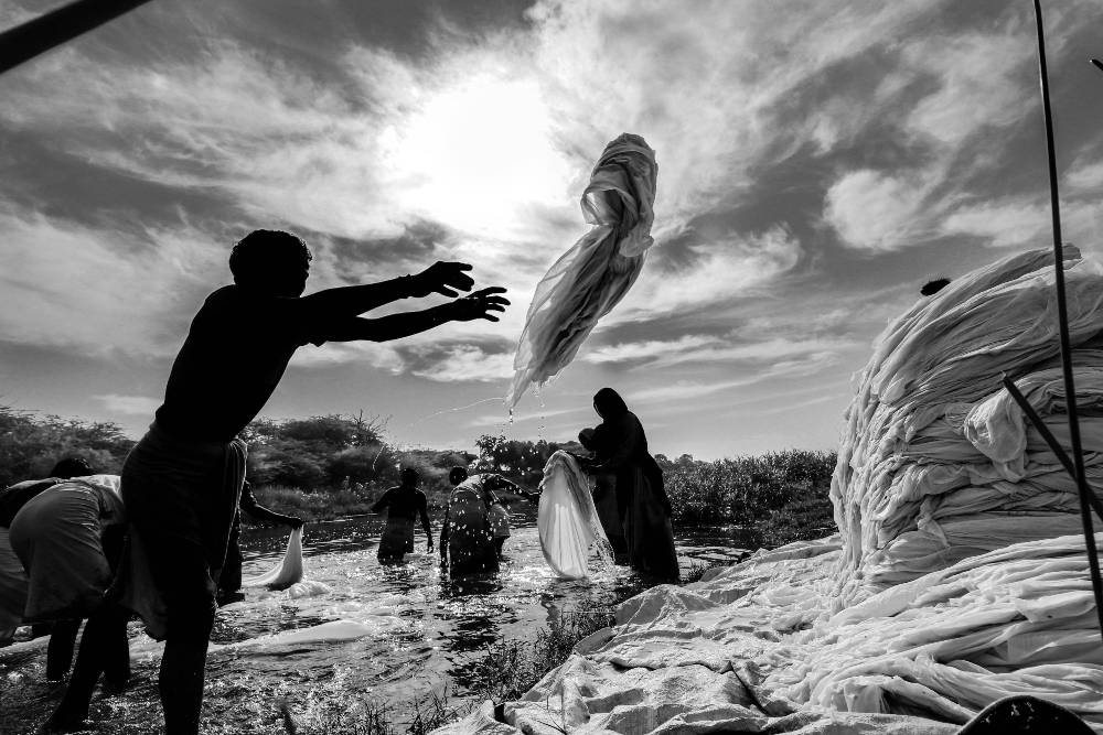 man in bangladesh throwing a garment.