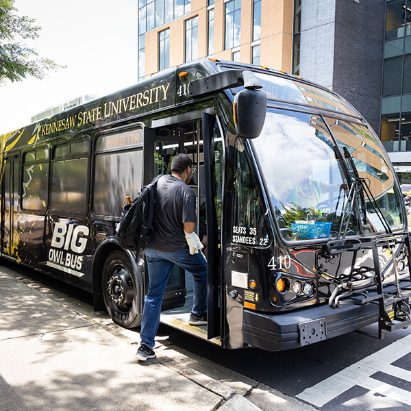 Student getting on the Big Owl Bus