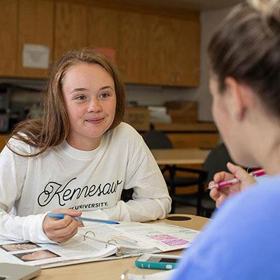 two ksu students sitting at a table collaborating