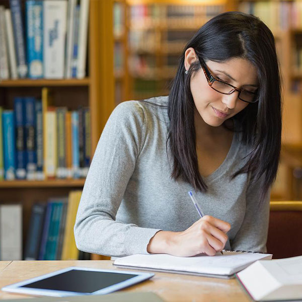 ksu student writing in their spiral notebook